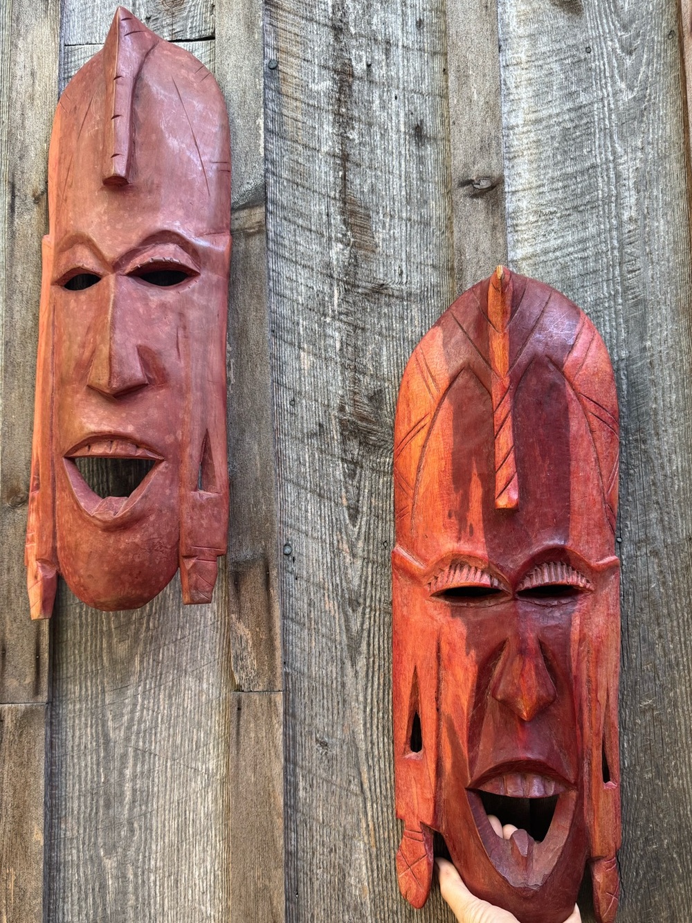 Set of large hand carved wooden masks in a deep red shade